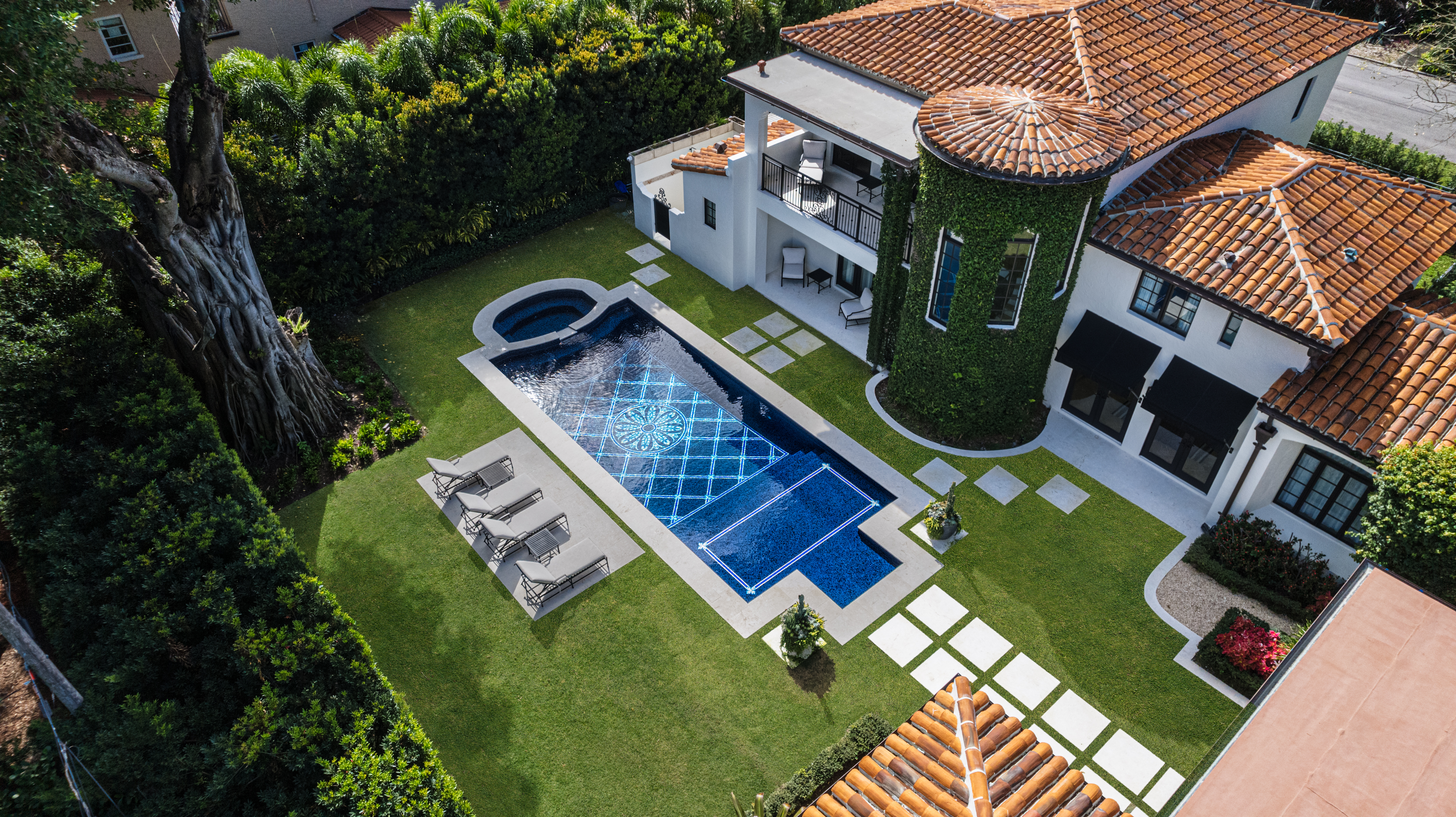 Luxury Coral Gables home with Mediterranean architecture, custom pool design, spa, and manicured backyard landscaping